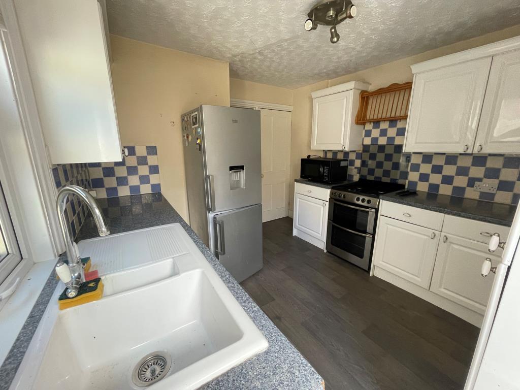 Lot: 144 - END-TERRACE PROPERTY ARRANGED AS THREE-BEDROOM HOUSE - Kitchen with fitted units and access to basement